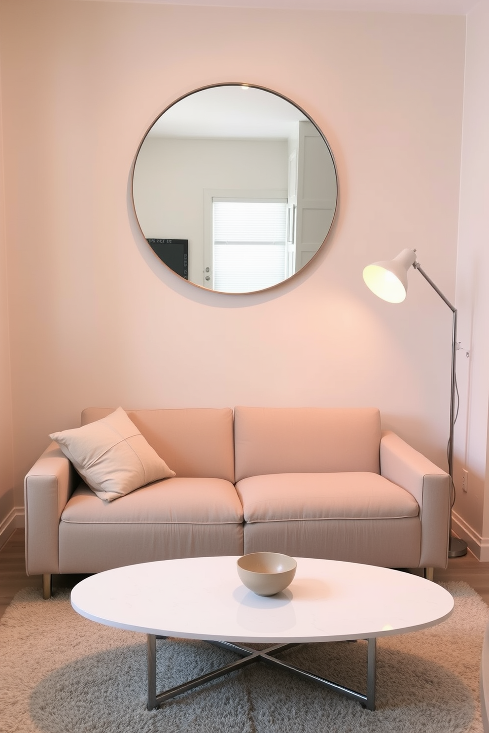 A cozy small apartment living room featuring a plush sofa in a neutral tone. A large round mirror hangs above a sleek coffee table, reflecting light and creating an illusion of space. The walls are adorned with soft pastel colors, enhancing the room's warmth. A stylish floor lamp stands in the corner, providing a warm glow for evening relaxation.