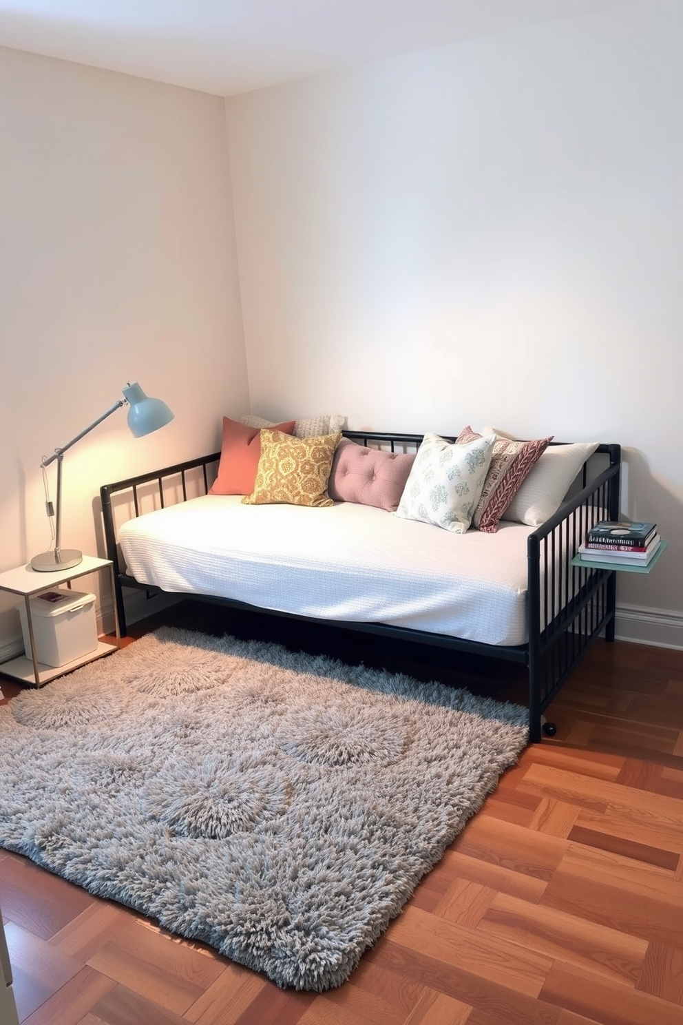 A cozy small bedroom featuring a stylish daybed that serves as both a seating area and a sleeping space. The walls are painted in a soft pastel hue, and a plush area rug adds warmth to the hardwood floor. On one side of the daybed, a sleek nightstand holds a modern lamp and a stack of books. Decorative pillows in various textures and patterns adorn the daybed, creating an inviting atmosphere.