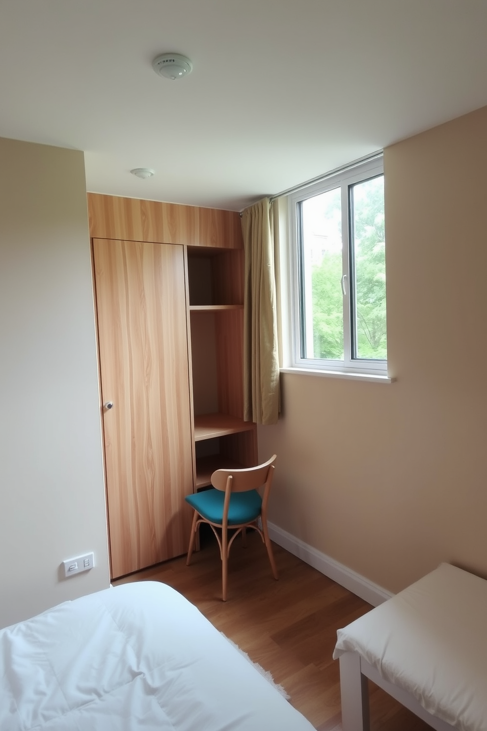 A cozy bedroom featuring a small desk area nestled by the window. The desk is made of light wood with a minimalist design, complemented by a comfortable chair that adds a pop of color. To the side, a small closet offers efficient storage with sliding doors. The bedroom walls are painted in a soft beige, creating a warm and inviting atmosphere.