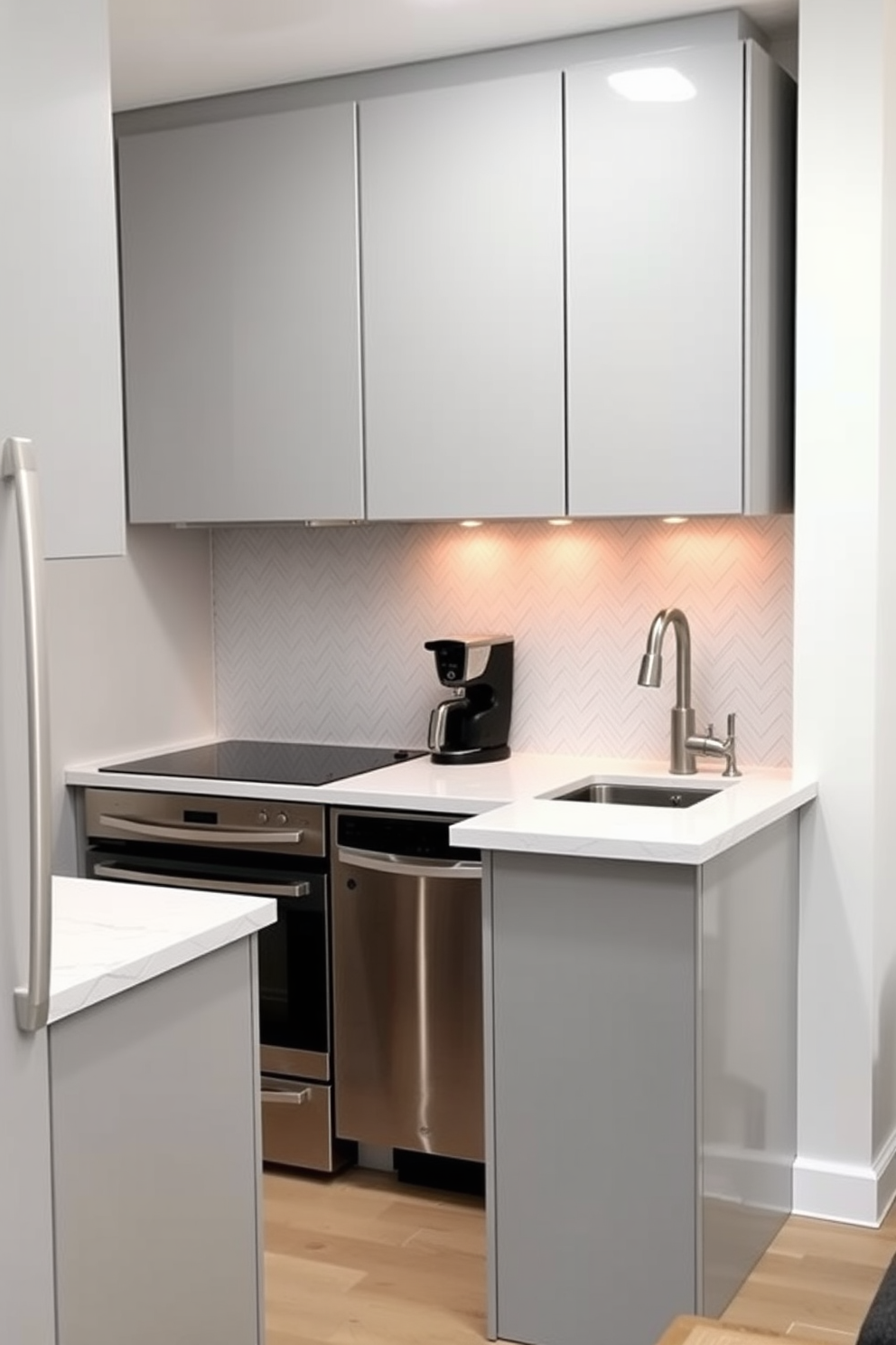 A small condo kitchen featuring sleek cabinetry in a soft gray finish. The space includes a compact island with bar seating and under-cabinet lighting that creates a warm ambiance. The countertops are a polished white quartz with subtle veining, complementing the stainless steel appliances. A stylish backsplash in a herringbone pattern adds texture and visual interest to the overall design.