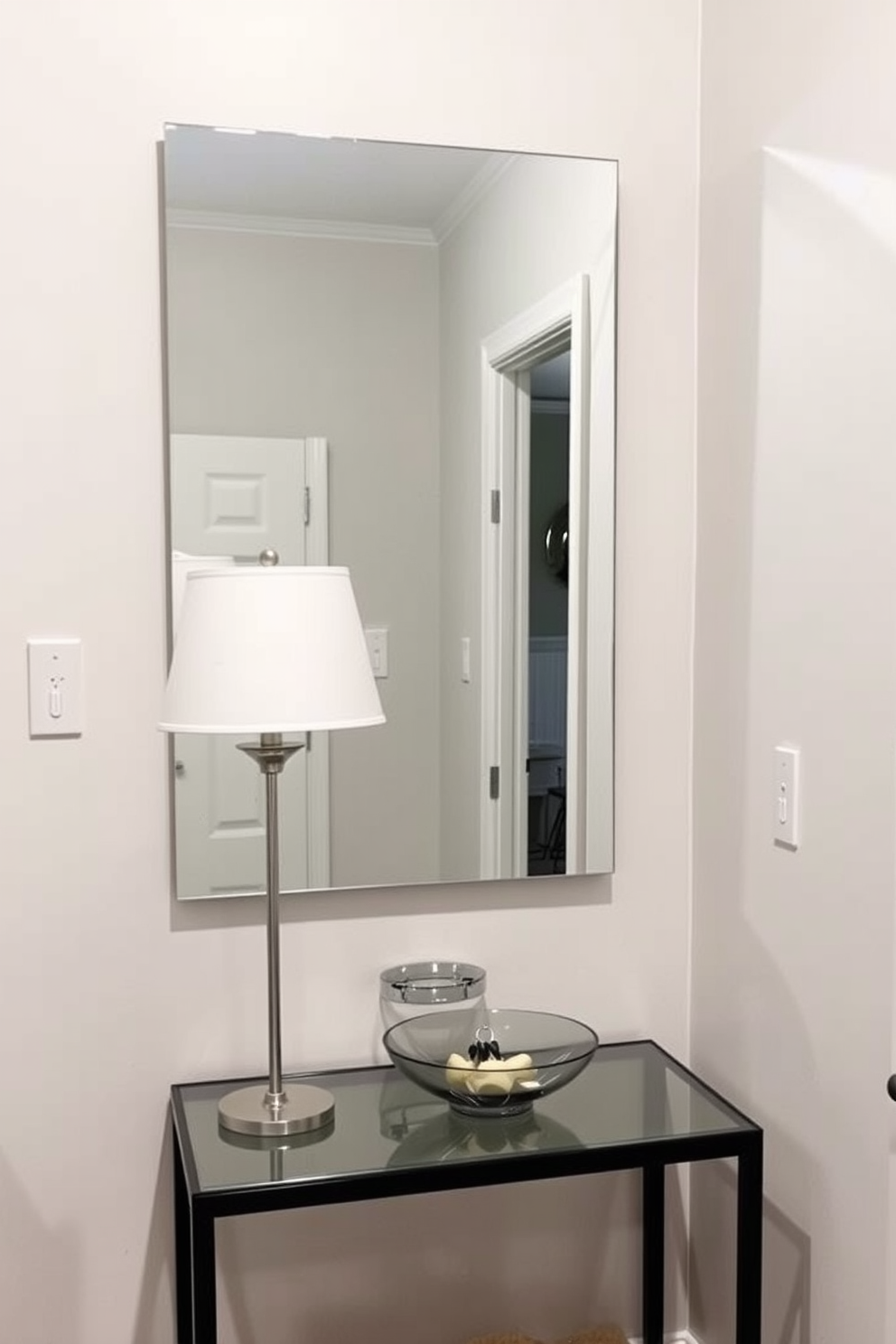 A small entryway with a functional mirror mounted on the wall for last-minute checks. The design features a compact console table beneath the mirror, with a stylish lamp and a decorative bowl for keys.