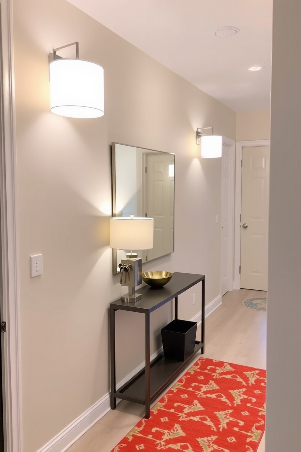 Bright lighting fixtures illuminate the small entryway, creating an inviting atmosphere. The space features a sleek console table against the wall, adorned with a stylish lamp and a decorative bowl for keys. A large mirror hangs above the console, reflecting the light and making the area feel more spacious. The walls are painted in a soft neutral tone, complemented by a vibrant area rug that adds a pop of color to the floor.