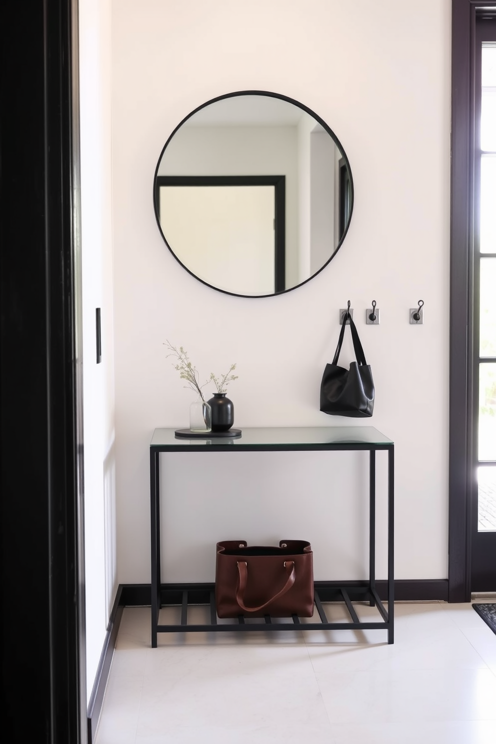 A small foyer features wall-mounted coat hooks strategically placed to maximize space efficiency. The walls are painted in a soft beige tone, complemented by a stylish console table with a decorative mirror above it.