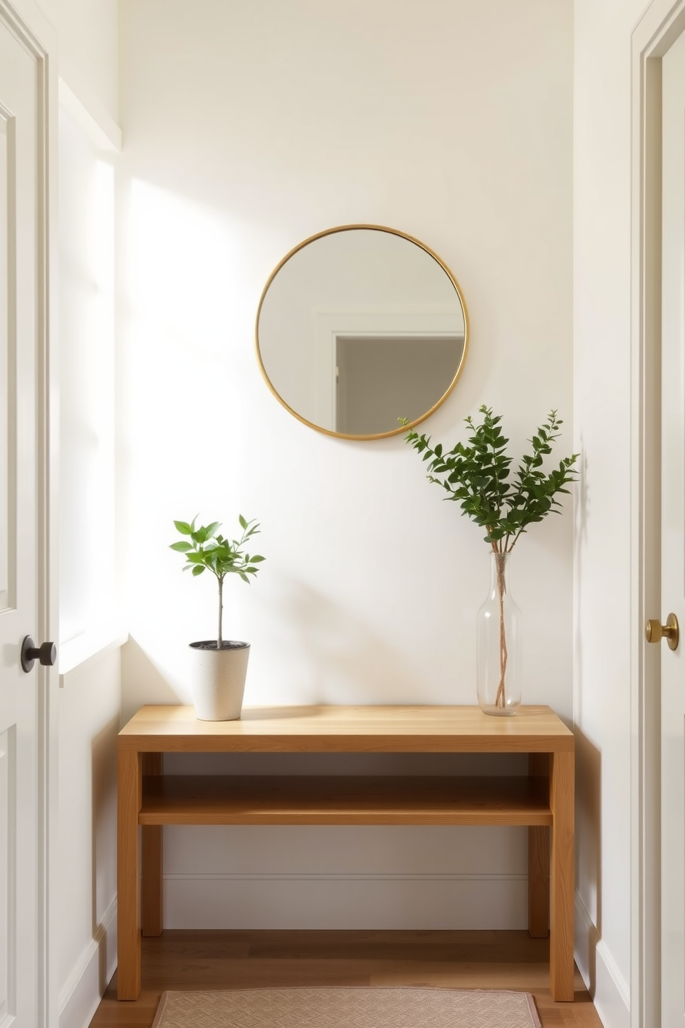 A small foyer design featuring a light color palette to enhance brightness. The walls are painted in a soft cream hue, complemented by a light oak console table against one side. A round mirror with a delicate gold frame hangs above the table, reflecting natural light. A small potted plant sits on the table, adding a touch of greenery and warmth to the space.