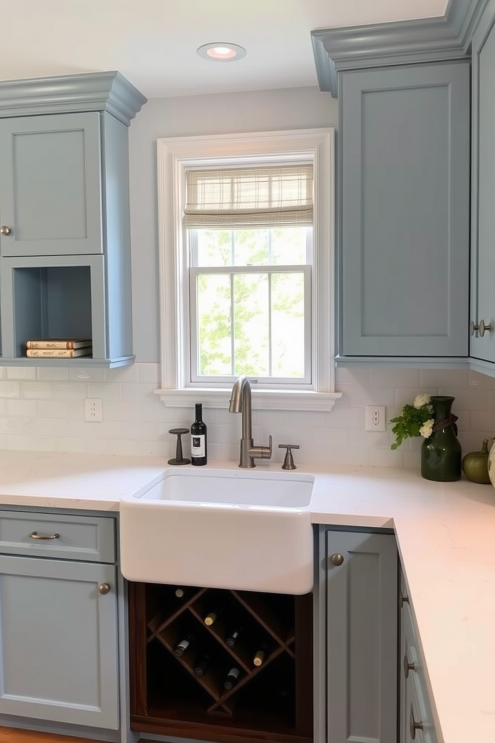 A cozy kitchen design featuring a small wine rack integrated into the cabinetry. The wine rack is made of dark wood and holds several bottles, adding a touch of elegance to the space. The countertops are a sleek white quartz, complemented by soft blue cabinetry that enhances the inviting atmosphere. A farmhouse sink sits beneath a window, allowing natural light to illuminate the room beautifully.