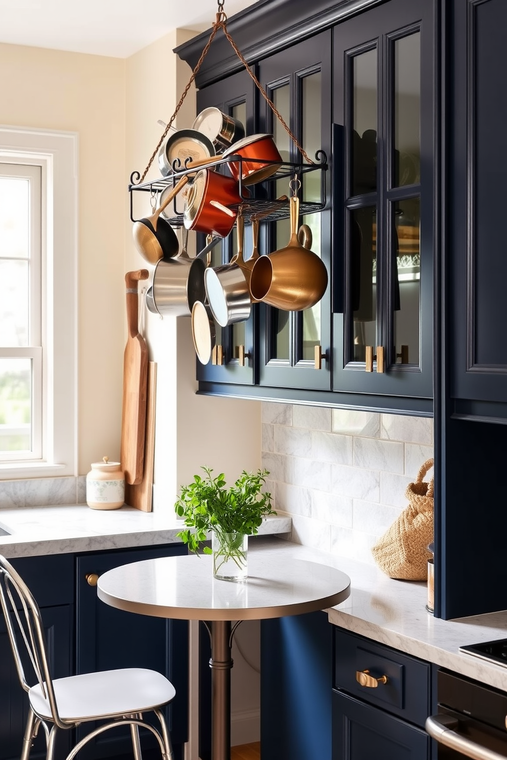 A cozy small kitchen featuring a hanging pot rack adorned with various cookware. The walls are painted in a soft cream color, and the cabinets are a rich navy blue, creating a warm and inviting atmosphere. The countertops are made of light gray quartz, providing a sleek surface for meal preparation. A small dining table with two chairs sits by the window, complemented by a vase of fresh herbs for a touch of greenery.