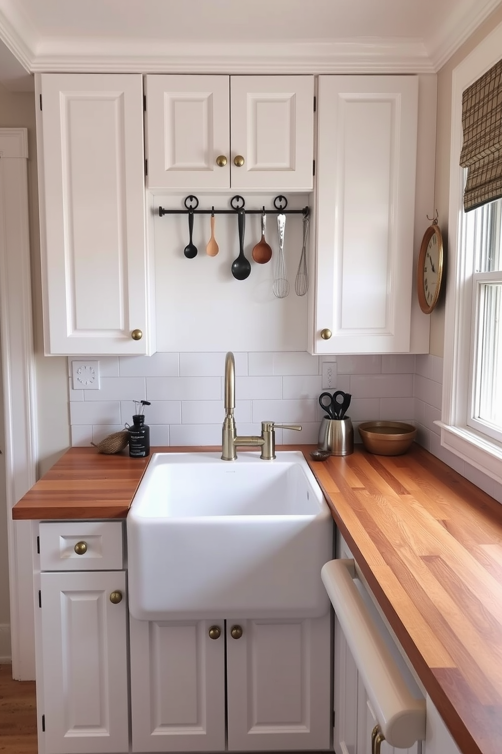 A cozy small kitchen design featuring white cabinetry with brass hardware and a charming farmhouse sink. Decorative hooks for utensils are installed above a wooden countertop, adding functionality and style to the space.