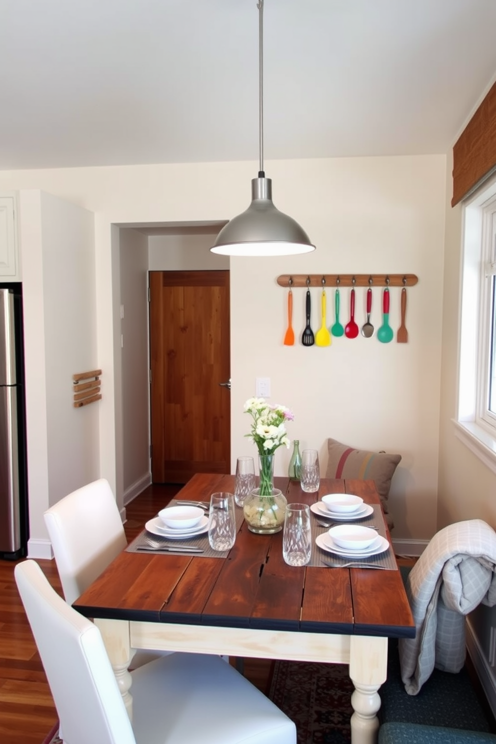 A cozy kitchen dining area featuring a wall-mounted table that maximizes space efficiency. The table is adorned with a simple vase of fresh herbs and paired with sleek, modern stools that complement the minimalist aesthetic. The walls are painted in soft white to create an airy feel, while open shelving displays neatly arranged dishware. A small pendant light hangs above the table, providing warm illumination for intimate meals.