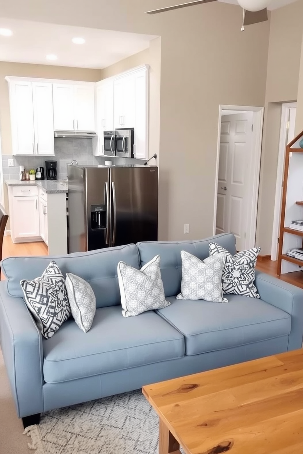 A cozy small kitchen living room design featuring a foldable table that can be easily tucked away when not in use. The space is brightened by natural light streaming in through large windows, and the decor includes light-colored cabinetry and a comfortable seating area.