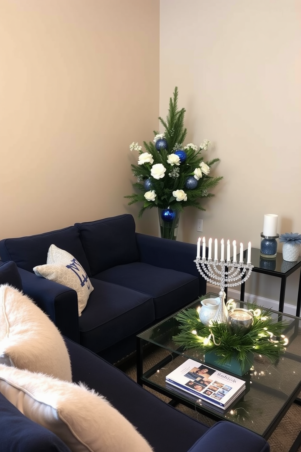 A cozy small living room adorned with creative seasonal greenery for Hanukkah. The space features a plush navy sofa with festive throw pillows, and a beautifully decorated menorah sits on the coffee table surrounded by twinkling fairy lights. An elegant arrangement of evergreen branches and white flowers is displayed in a glass vase on a side table. The walls are painted a soft beige, creating a warm backdrop for the blue and silver decorations that enhance the holiday spirit.