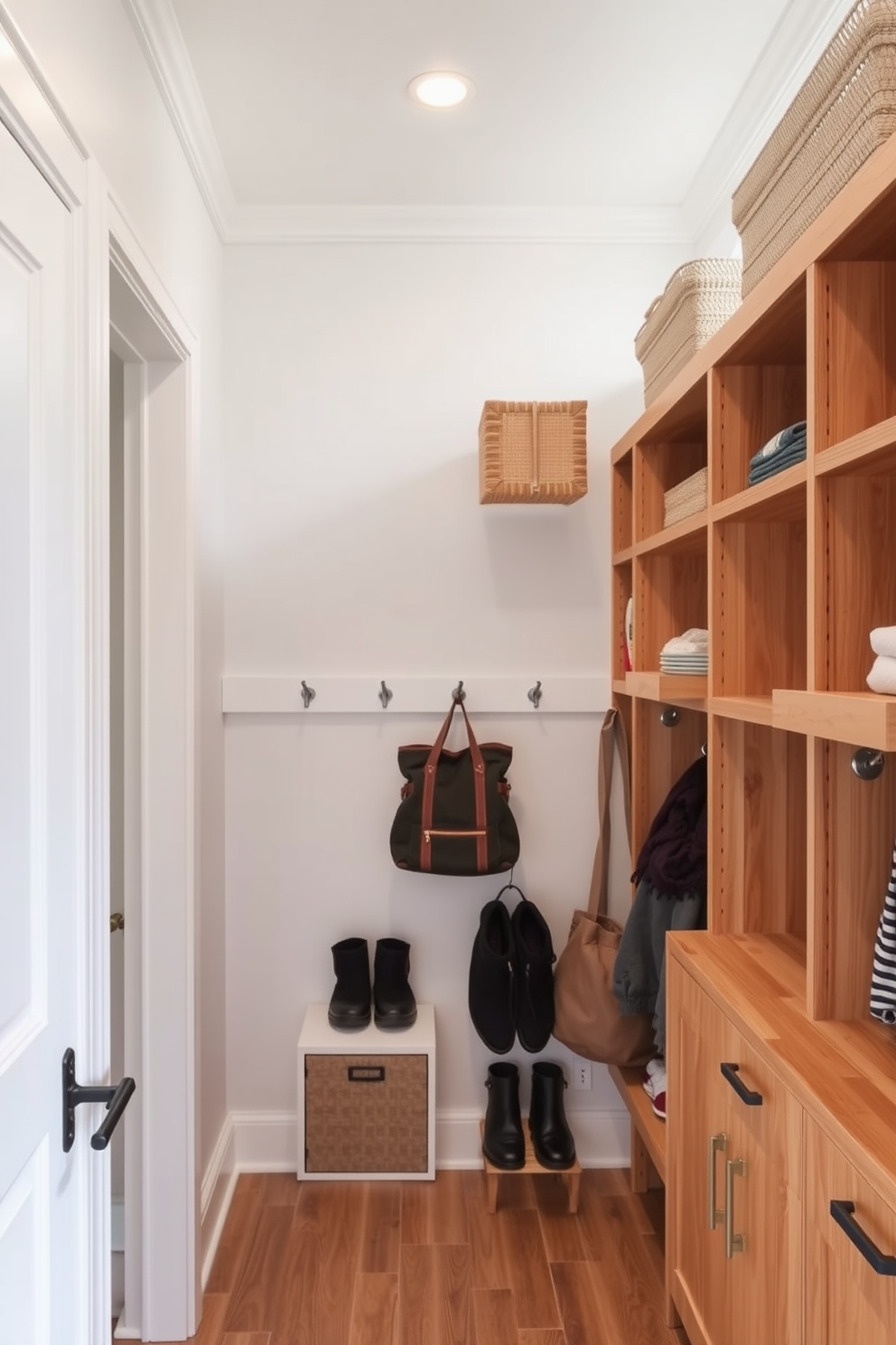 Open shelving lines the walls of a small mudroom, providing easy access to everyday items like shoes, bags, and outdoor gear. The space features a combination of natural wood and white finishes, creating a bright and inviting atmosphere.