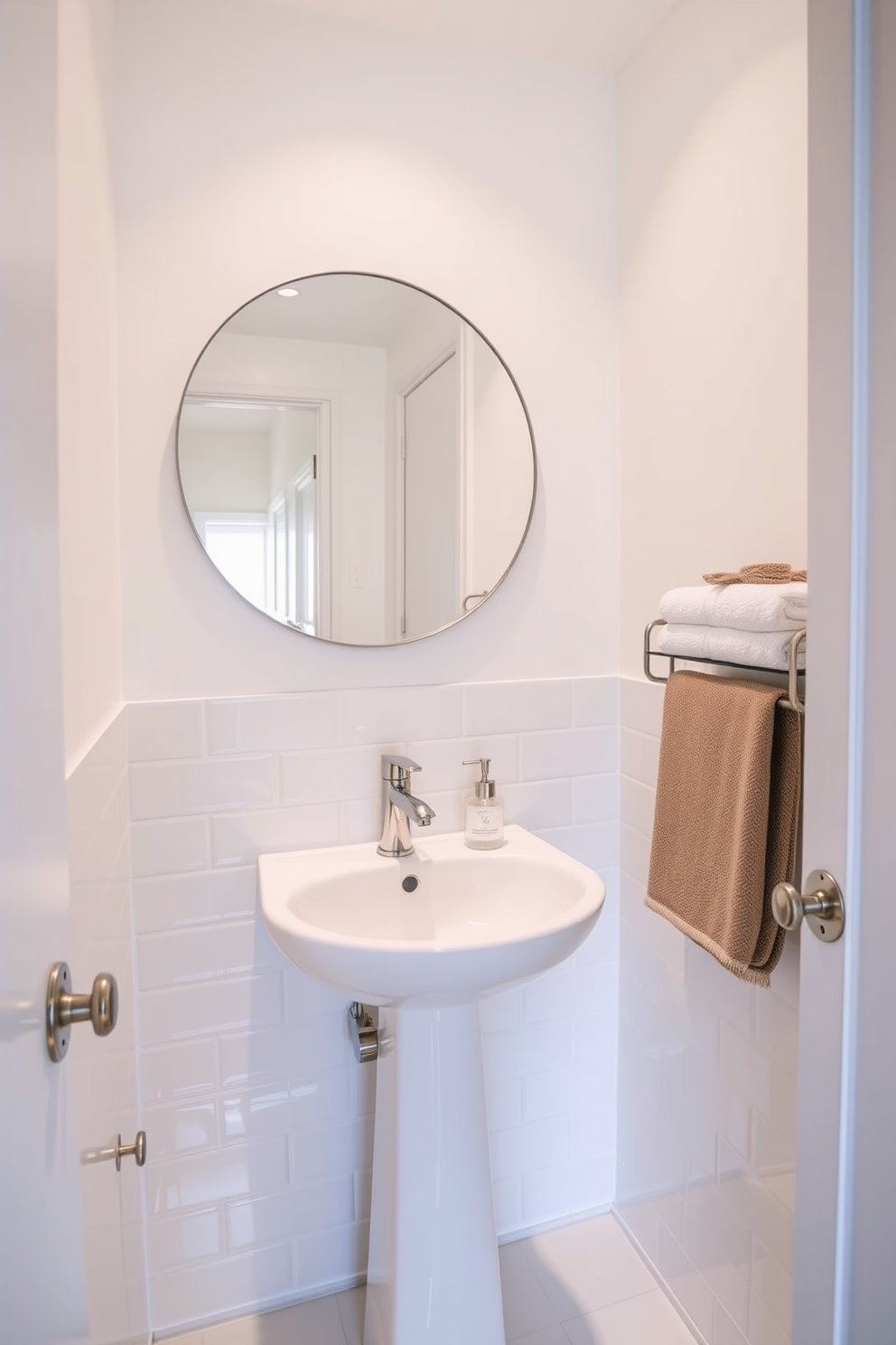 Bright lighting to enhance space. The small powder room features a sleek pedestal sink with a polished chrome faucet, surrounded by light-reflecting tiles that create an illusion of depth. The walls are painted in a soft white hue, complemented by a large round mirror that amplifies the natural light. A stylish wall-mounted shelf holds neatly folded towels and decorative accents, adding a touch of elegance to the compact area.