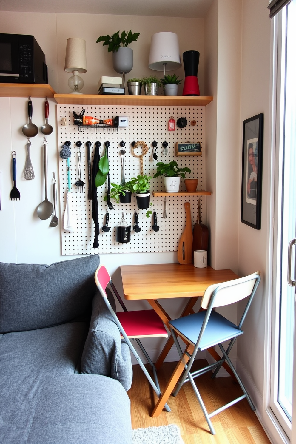 A small studio apartment featuring a cozy living area with a light gray sofa that has exposed wooden legs. Adjacent to the sofa, a round glass coffee table with a brass frame adds an airy feel to the space. The kitchen area showcases sleek white cabinetry with open shelving displaying colorful dishware. A compact dining table with slender legs and minimalist chairs creates a functional yet stylish dining nook.