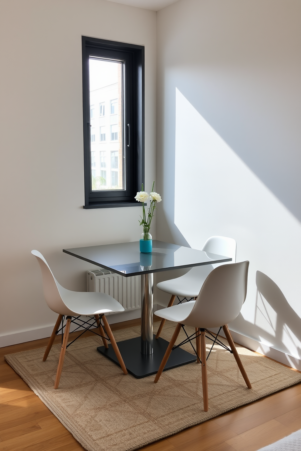 A compact dining table with sleek lines and a minimalist design is placed against a wall in a small studio apartment. Surrounding the table are four stylish chairs that can be easily tucked away when not in use, maximizing the available space. The dining area features a cozy nook with a large window, allowing natural light to flood the room. A soft area rug under the table adds warmth and texture, creating an inviting atmosphere for meals and gatherings.