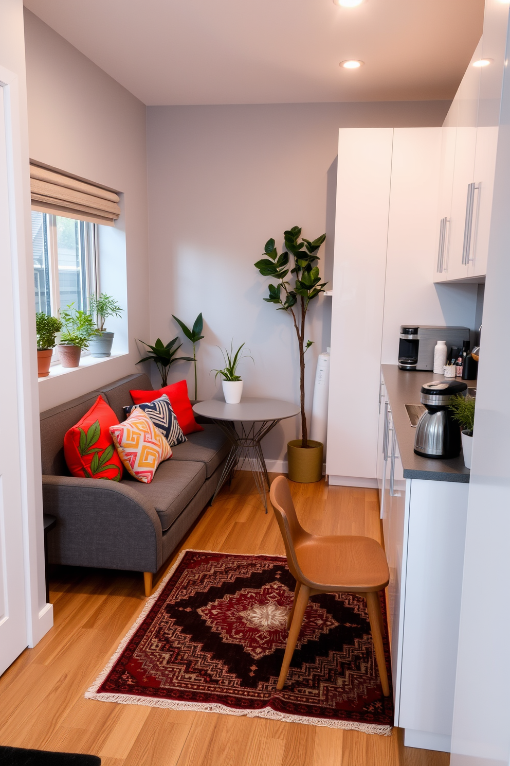 A cozy small studio apartment featuring a comfortable sofa with colorful throw pillows against a light gray wall. A small dining table with two chairs is positioned near a window, surrounded by potted plants that add a touch of greenery and freshness to the space. The kitchen area is designed with sleek white cabinets and a compact countertop, showcasing a modern coffee maker and a few decorative items. A stylish rug lies beneath the seating area, complementing the overall aesthetic while enhancing the warmth of the room.