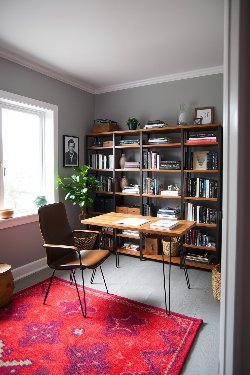 A cozy study room featuring a blend of mid-century modern and industrial furniture styles. A sleek wooden desk with hairpin legs is paired with a vintage leather armchair and a rustic bookshelf filled with books and decorative items. The walls are painted in a soft gray, creating a calm atmosphere for work. A large window allows natural light to flood the space, complemented by a colorful area rug that adds warmth and personality.