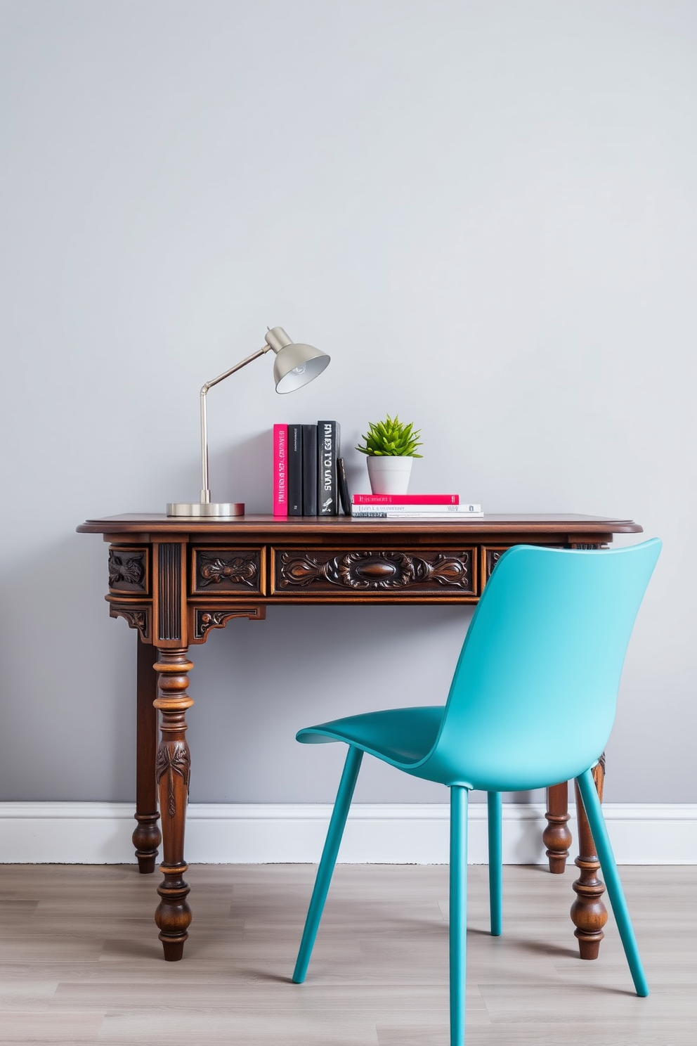 A vintage wooden desk with intricate carvings sits against a soft gray wall. A sleek modern chair in a vibrant color contrasts beautifully with the desk, creating a unique blend of styles. The desk is adorned with a stylish desk lamp and a few carefully arranged books. A small potted plant adds a touch of greenery to the space, enhancing the inviting atmosphere.