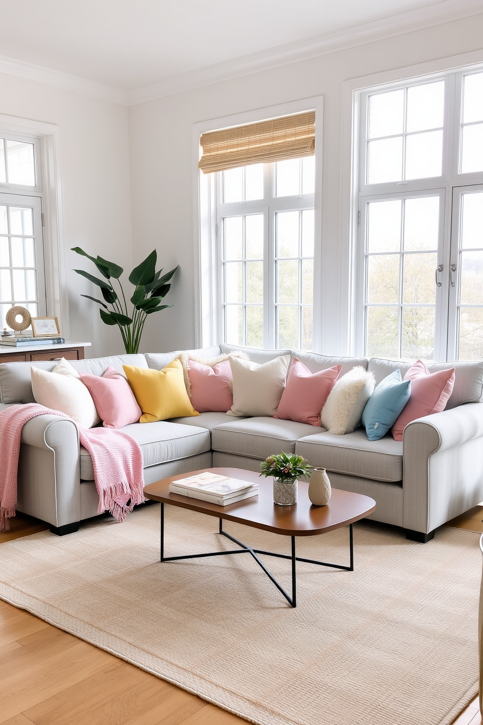 A cozy living room featuring a light gray sofa adorned with an array of pastel-colored throw pillows in soft pinks, blues, and yellows. The room is brightened by large windows that invite natural light, complemented by a neutral area rug that ties the space together. A small coffee table sits in front of the sofa, adorned with a few decorative books and a small potted plant. The walls are painted in a soft white, providing a fresh backdrop for the vibrant colors of the pillows and decor.