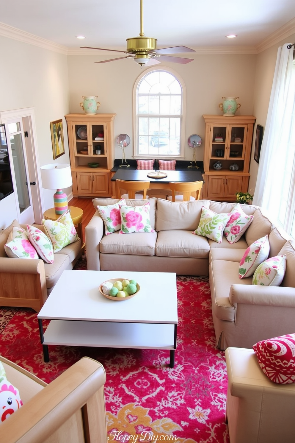 A bright and airy game room features light-colored furniture that enhances the sense of openness. The space includes a comfortable sectional sofa in soft beige, paired with a sleek white coffee table and oversized floor cushions in pastel shades. A large window allows natural light to flood the room, complemented by light wooden flooring. Wall-mounted shelves display colorful board games and decorative items, while a vibrant area rug adds a playful touch to the floor.