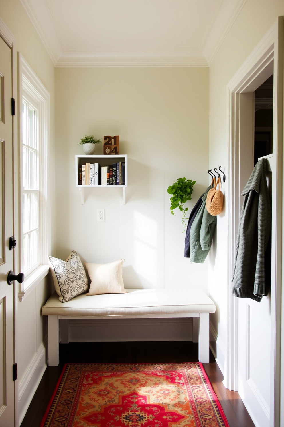 A charming mudroom filled with natural light. There is a small bookshelf in the corner, adorned with neatly arranged books and a couple of decorative plants. The walls are painted in a soft pastel hue, creating a welcoming atmosphere. A bench with plush cushions sits against the wall, surrounded by hooks for coats and a vibrant rug on the floor.