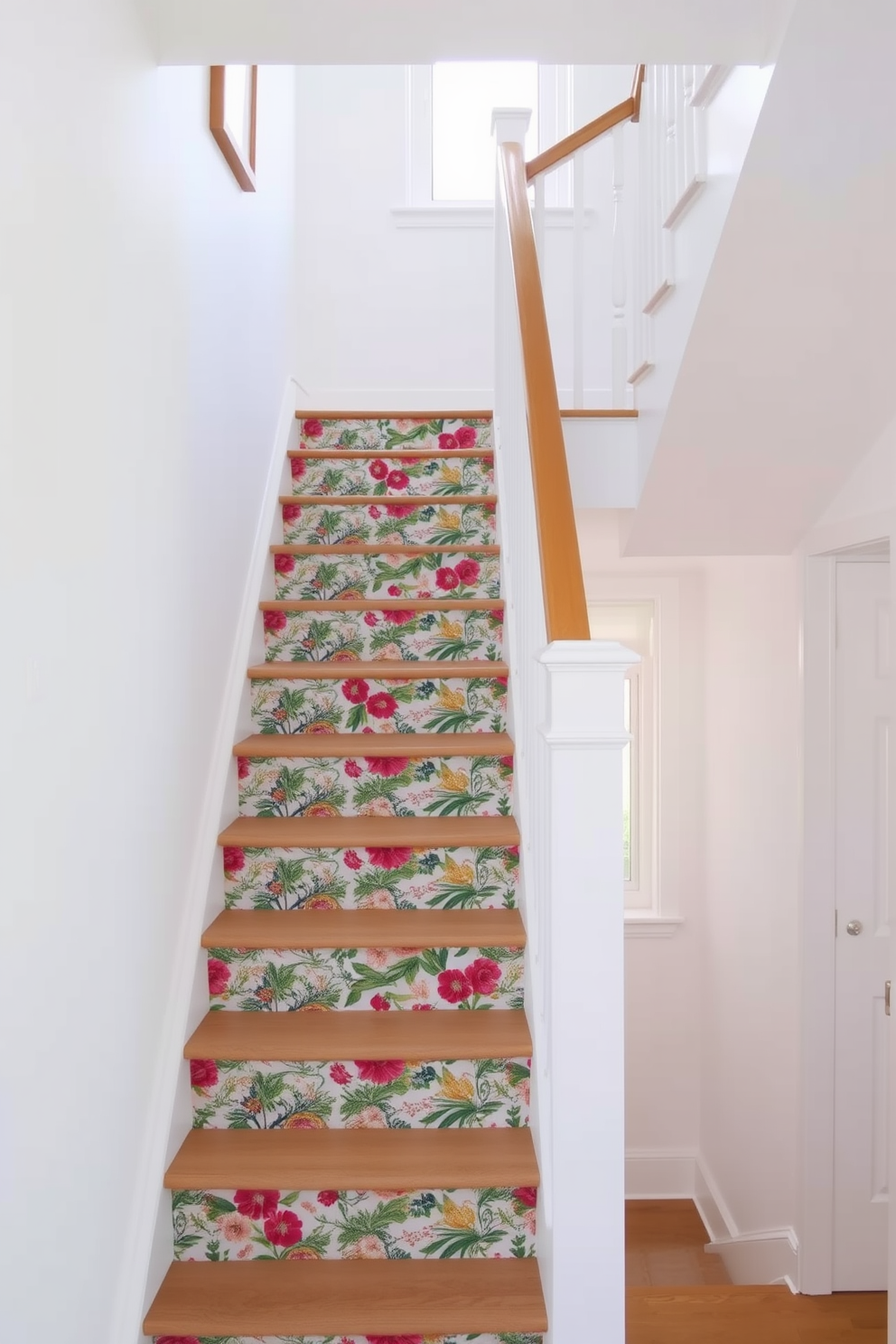 A bright and airy staircase features temporary wallpaper on the risers, showcasing a vibrant floral pattern that adds a touch of whimsy. The surrounding walls are painted in a soft white, allowing the wallpaper to stand out while natural light floods the space through a nearby window.