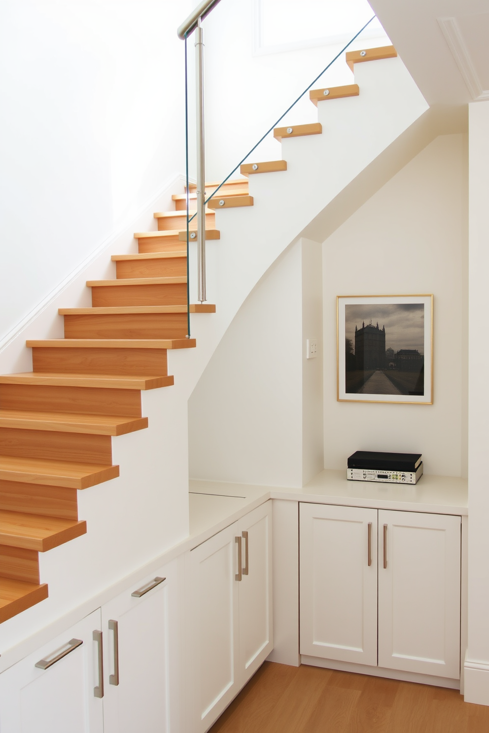 A modern staircase with integrated storage solutions features sleek wooden steps that gracefully ascend. Beneath the staircase, built-in cabinets with minimalist handles provide ample storage while maintaining a clean aesthetic. The walls surrounding the staircase are painted in a soft neutral tone, enhancing the brightness of the space. A stylish railing made of glass and metal adds an elegant touch, allowing light to flow freely throughout the area.