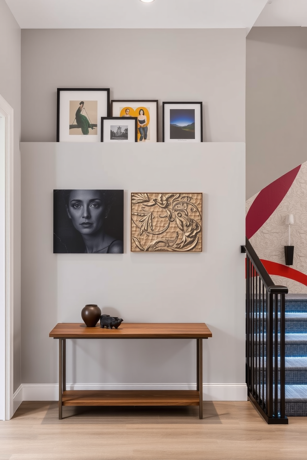 A gallery ledge is elegantly positioned against a light gray wall, adorned with a curated selection of artwork that rotates regularly. Below the ledge, a sleek wooden console table holds a few carefully chosen decorative items, enhancing the artistic ambiance of the space. The staircase features a striking wall design, incorporating a mix of textured panels and painted accents in bold colors. Soft LED lighting illuminates the design, creating a dramatic effect as it guides the eye upwards.