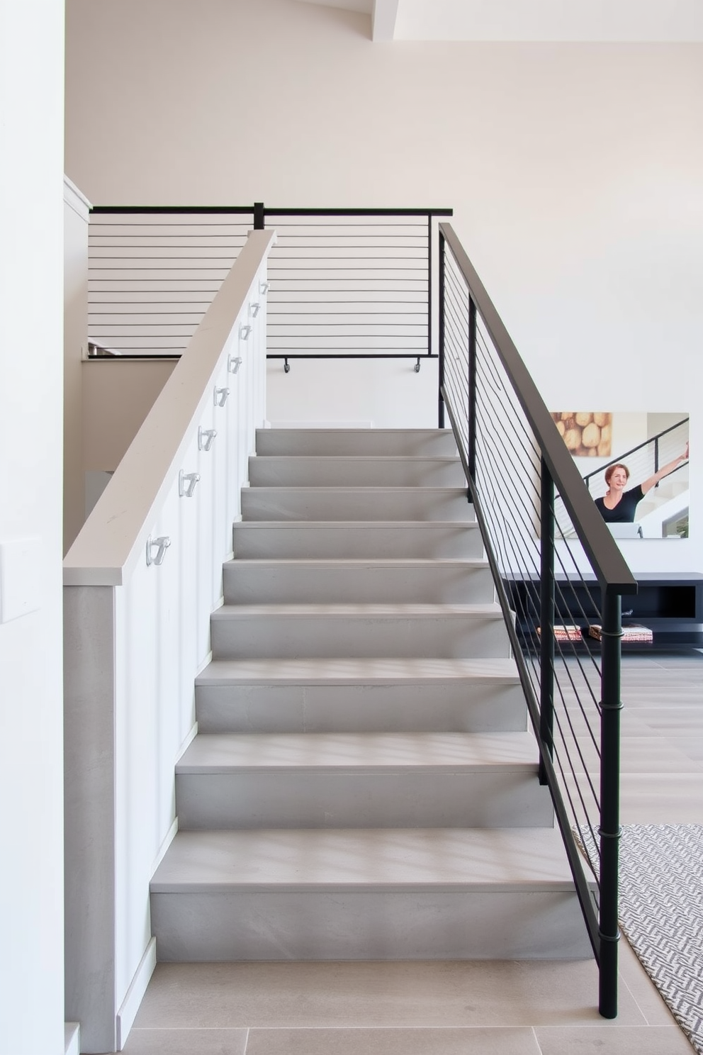 A modern staircase features sleek concrete steps that lead gracefully to the upper level. The minimalist railing complements the contemporary aesthetic, adding an element of sophistication to the family room design.