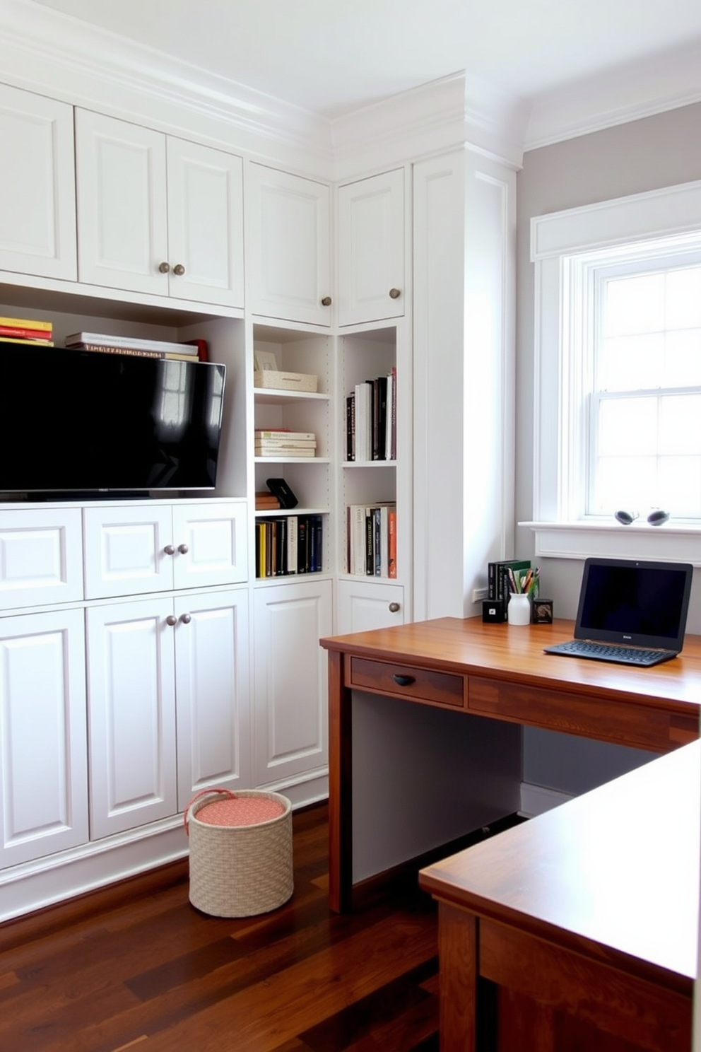 A cozy study room featuring built-in cabinetry that provides organized storage solutions. The cabinetry is painted in a soft white finish, seamlessly blending with the light gray walls, while a large wooden desk is positioned in front of a window, allowing natural light to illuminate the space.