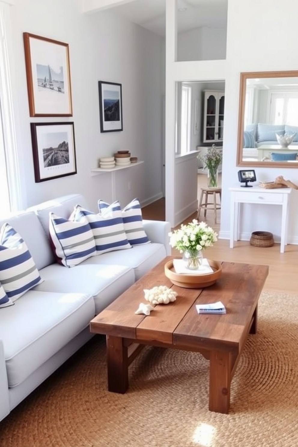 A bright and airy summer apartment filled with nautical accents. The living room features a light blue sofa adorned with striped throw pillows and a coffee table made of reclaimed wood. On the walls, framed coastal prints and a large mirror reflect natural light. A jute rug anchors the space, while decorative elements like seashells and driftwood complete the coastal charm.