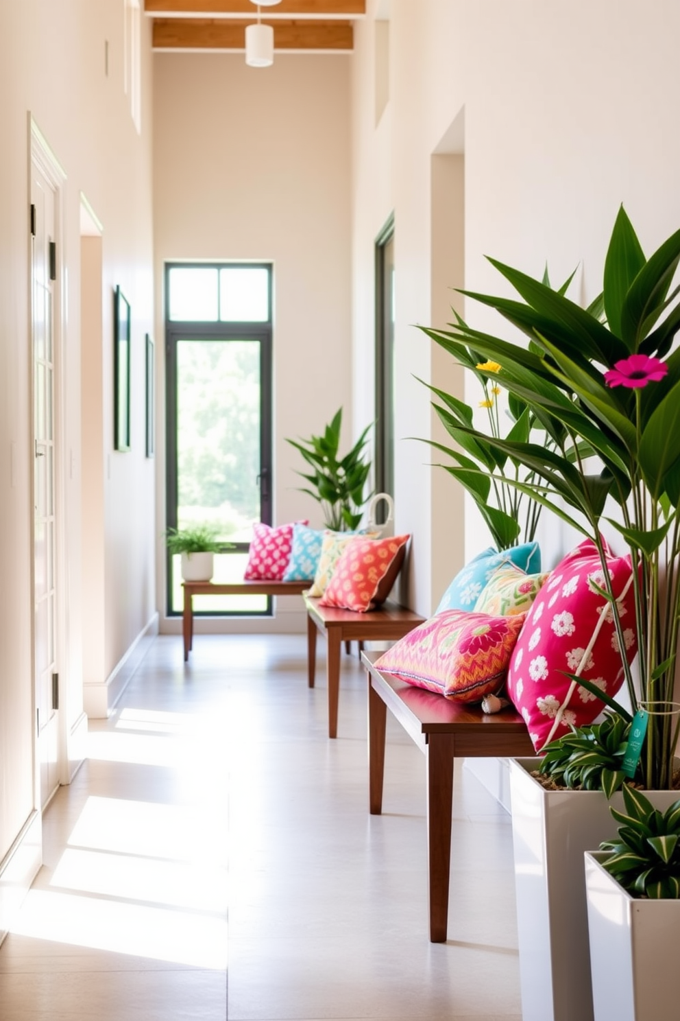 Colorful throw pillows are arranged on sleek wooden benches, adding a vibrant touch to the space. The hallway is brightened by natural light streaming in through large windows, creating an inviting atmosphere. A mix of floral and geometric patterns on the pillows enhances the playful summer theme. Fresh greenery in stylish planters complements the decor, bringing a sense of life and warmth to the hallway.