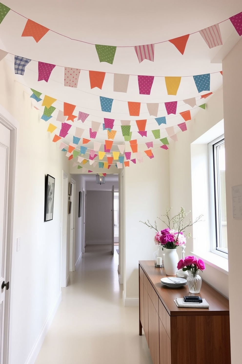 A bright and airy hallway adorned with colorful fabric bunting strung across the ceiling. The walls are painted in a soft pastel hue, complemented by a sleek wooden console table topped with fresh flowers and decorative accents.