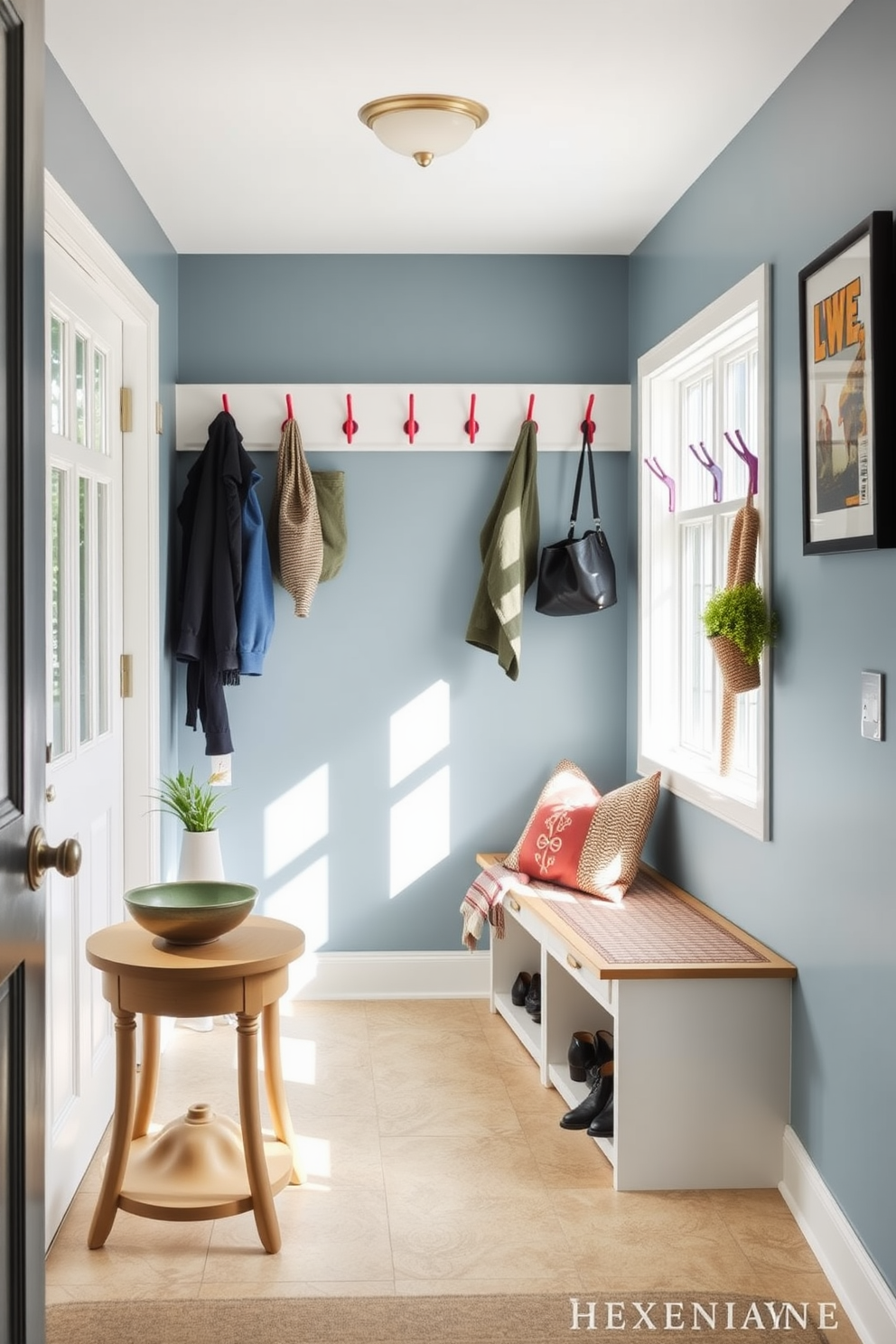 A welcoming mudroom filled with natural light. There is a small table for keys positioned near the entrance, topped with a decorative bowl and a small potted plant. The walls are painted in a soft blue hue, creating a refreshing atmosphere. A bench with storage underneath provides a cozy spot to sit and remove shoes, complemented by colorful hooks for hanging bags and jackets.