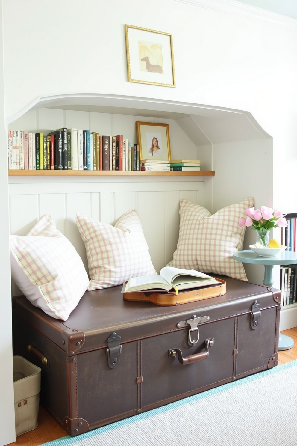 A cozy summer reading nook features a vintage trunk that serves as both storage and seating. The nook is adorned with soft cushions in pastel colors, surrounded by shelves filled with books and a small side table for refreshments.