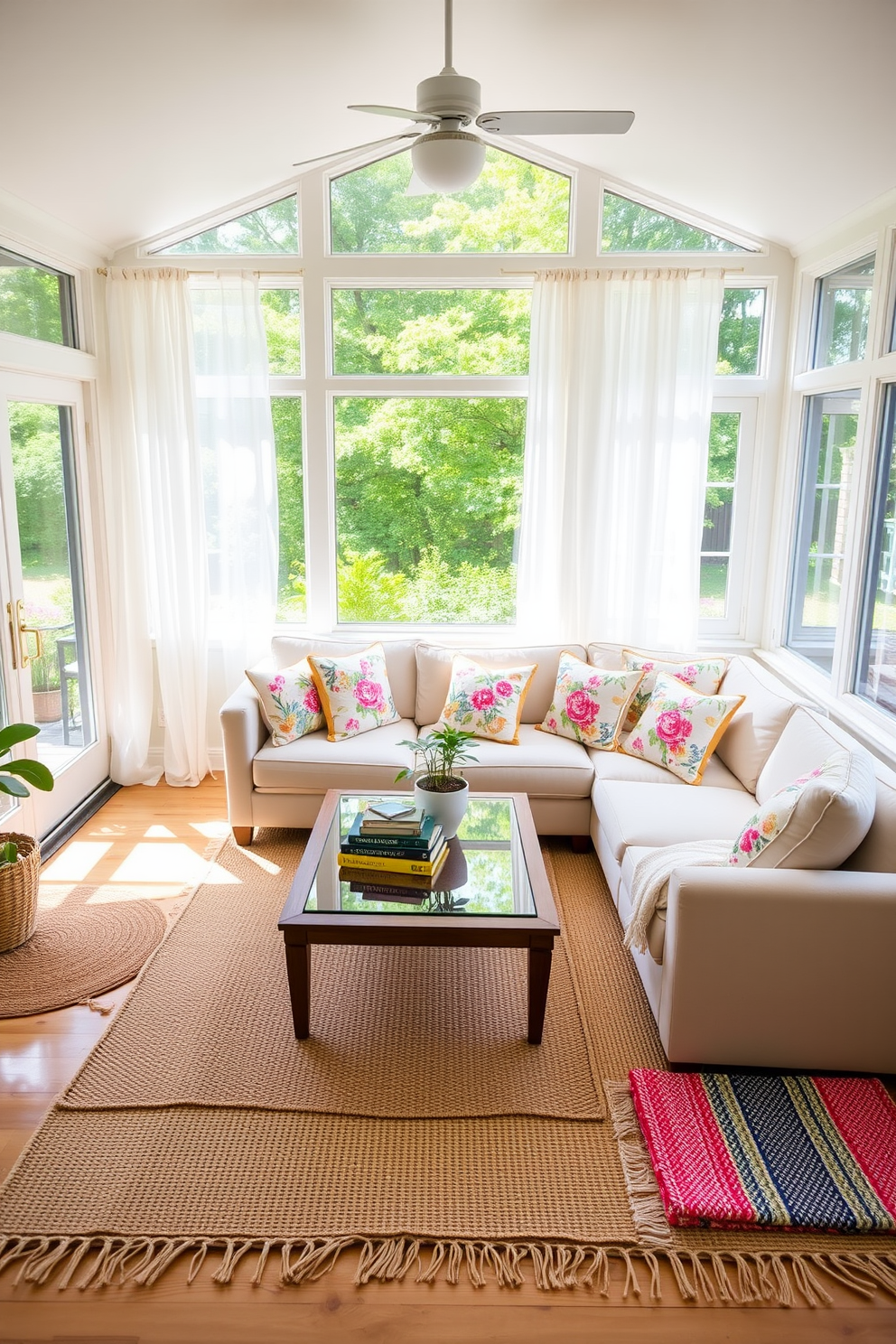 A bright and airy sunroom filled with natural light. The space features large windows adorned with sheer white curtains, offering a view of a lush garden outside. In the center, a comfortable seating area is arranged with a plush sectional sofa in a soft pastel hue. Layered on the floor are a variety of textured rugs, including a jute rug and a colorful woven throw, adding warmth and dimension to the space. A wooden coffee table with a glass top sits atop the rugs, adorned with a few decorative books and a small potted plant. To enhance the summer vibe, vibrant cushions in floral patterns are scattered across the sofa, inviting relaxation and enjoyment of the sunny atmosphere.