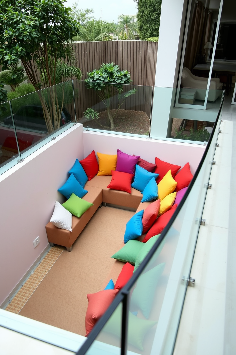 A sunken living room features a cozy arrangement of colorful cushions in vibrant hues scattered across a plush sectional sofa. The sunken area is framed by a sleek glass railing, allowing for an open and inviting atmosphere that encourages relaxation and conversation.