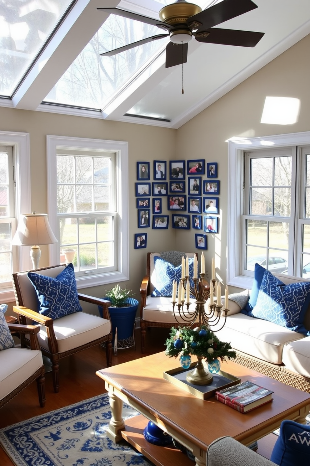 A cozy sunroom filled with natural light featuring a family photo collage displayed in blue frames on the wall. The decor is enhanced with festive Hanukkah decorations, including a menorah on the coffee table and blue and silver accents throughout the space.