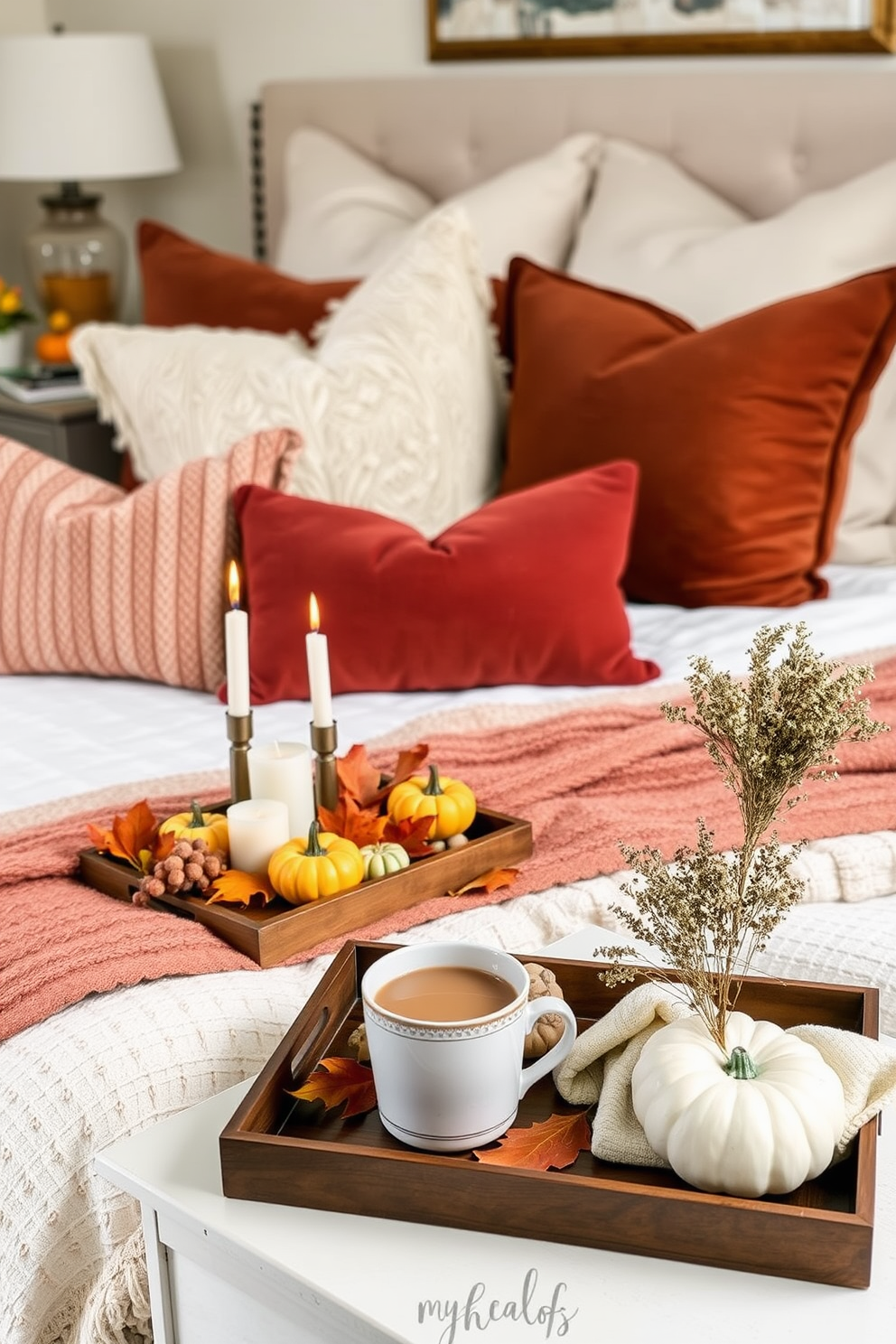 A cozy bedroom setting adorned with decorative trays showcasing seasonal items for Thanksgiving. The trays are filled with miniature pumpkins, scented candles, and autumn leaves, creating a warm and inviting atmosphere. The bed is dressed in rich, earthy tones with plush pillows and a soft throw blanket. A bedside table features a tray that holds a steaming mug of cider and a small bouquet of dried flowers, adding to the seasonal charm.