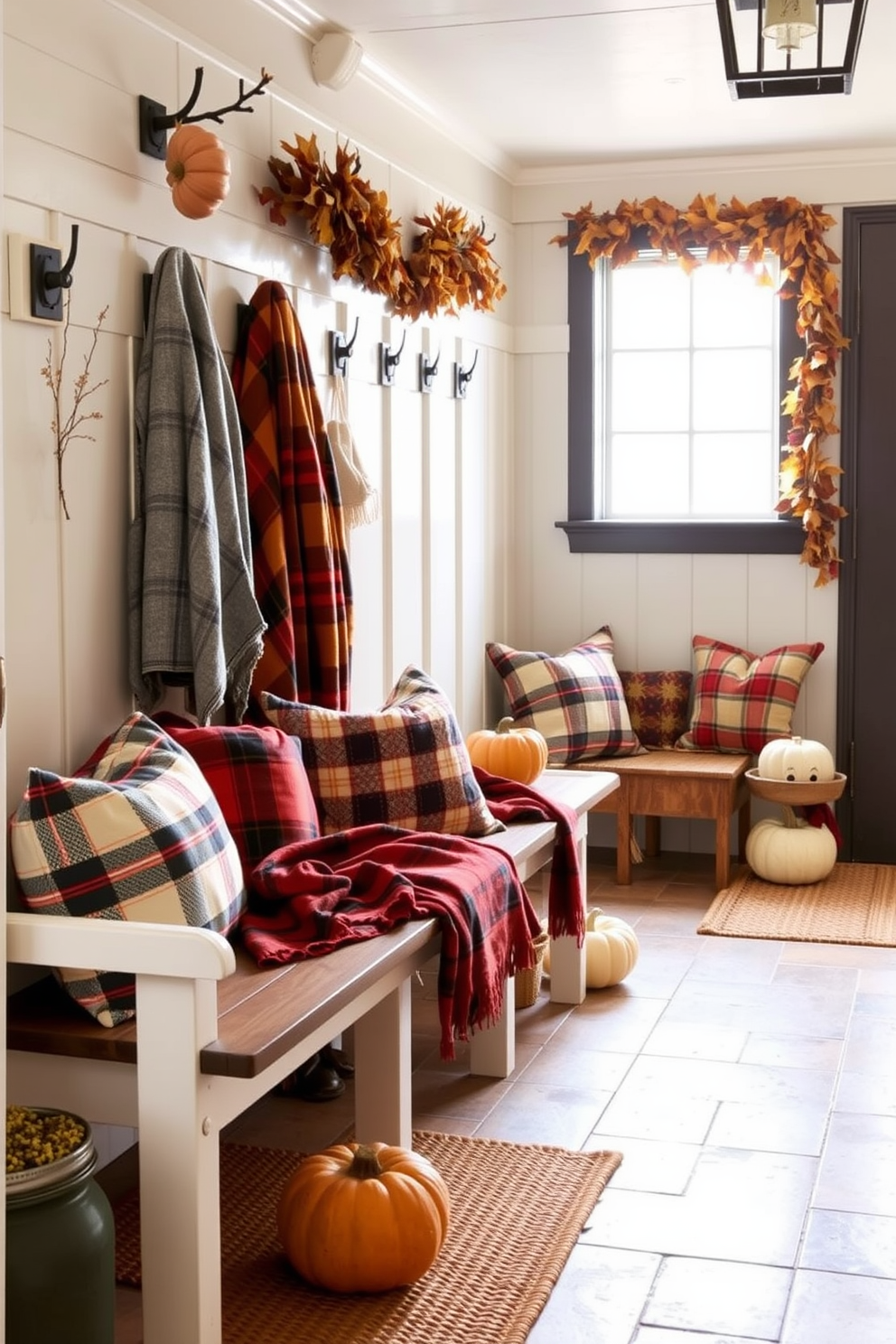 A welcoming mudroom features benches adorned with cozy plaid throw blankets in warm autumn colors. The space is accented with seasonal decorations like pumpkins and a garland of dried leaves to create a festive atmosphere for Thanksgiving.