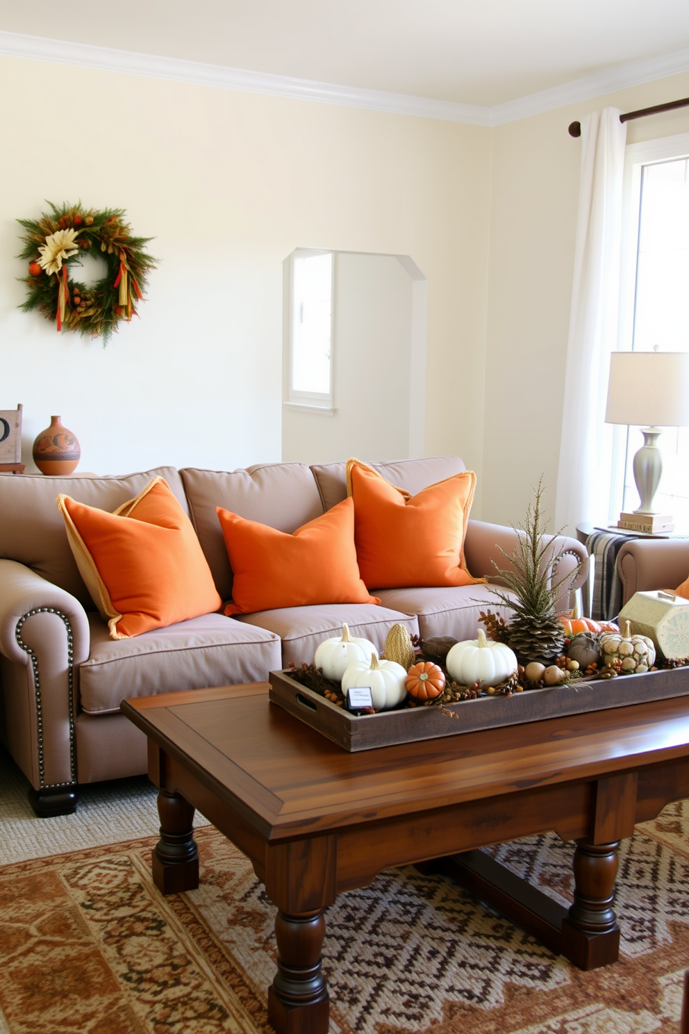 A cozy living room setting adorned with warm orange throw pillows placed on a plush sofa. The walls are painted in a soft cream color, and a rustic wooden coffee table sits in front of the sofa, topped with seasonal decorations for Thanksgiving.