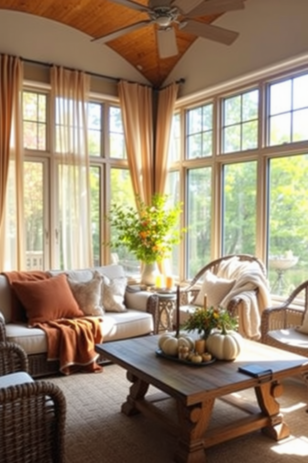 A cozy sunroom filled with natural light. Soft blankets in warm autumn colors are draped over a plush sofa and wicker chairs, creating an inviting atmosphere for relaxation. The space features large windows adorned with sheer curtains that gently filter the sunlight. A rustic wooden coffee table is topped with seasonal decorations, including pumpkins and candles, enhancing the Thanksgiving theme.