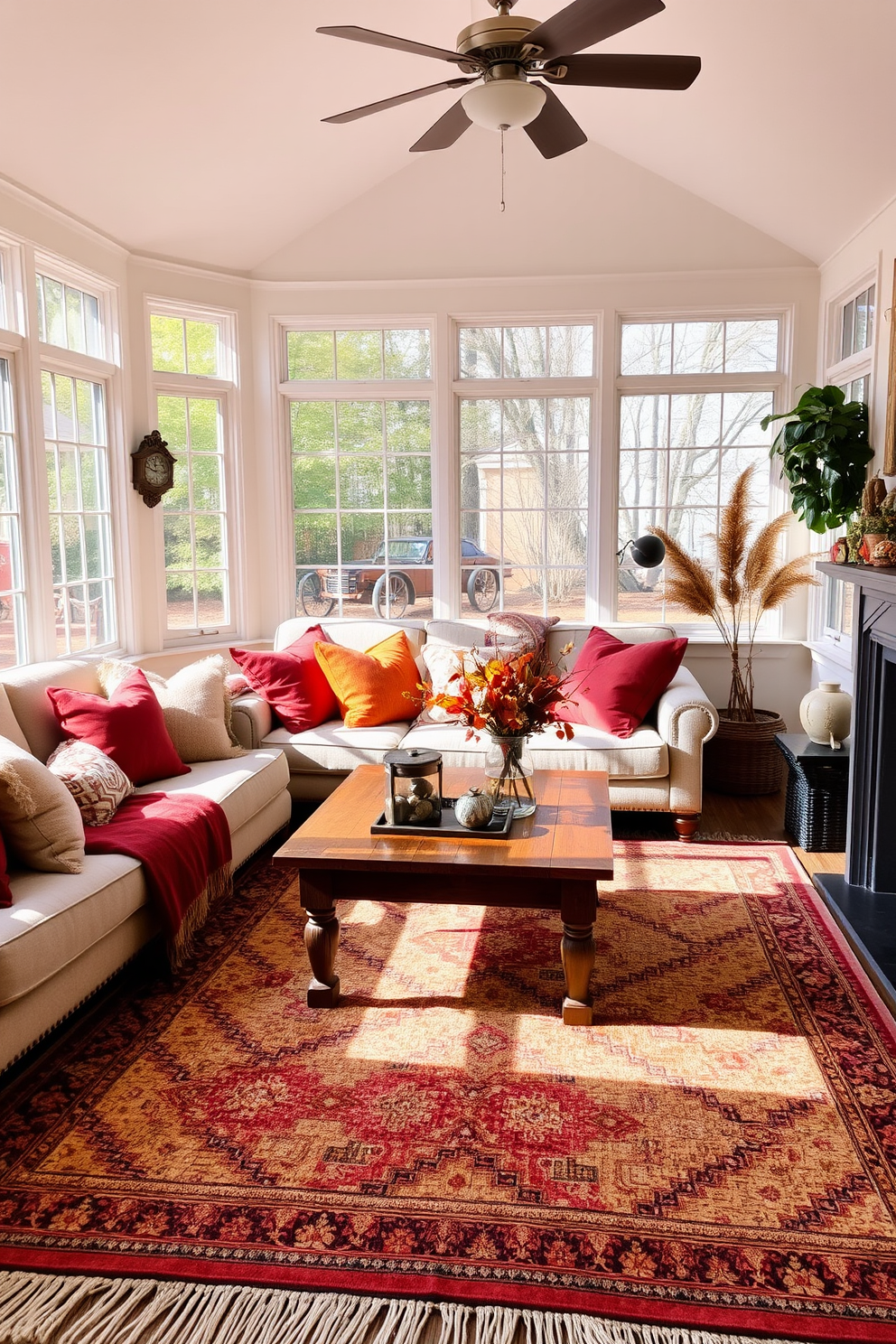 A harvest-themed table runner stretches elegantly across a rustic wooden dining table adorned with autumn leaves and small pumpkins. Golden and deep orange hues create a warm atmosphere, complemented by flickering candlelight from decorative holders. In the sunroom, large windows invite natural light, showcasing a cozy seating area filled with plush cushions and soft blankets. Potted plants and seasonal decorations enhance the inviting ambiance, making it the perfect space for relaxation and gathering.