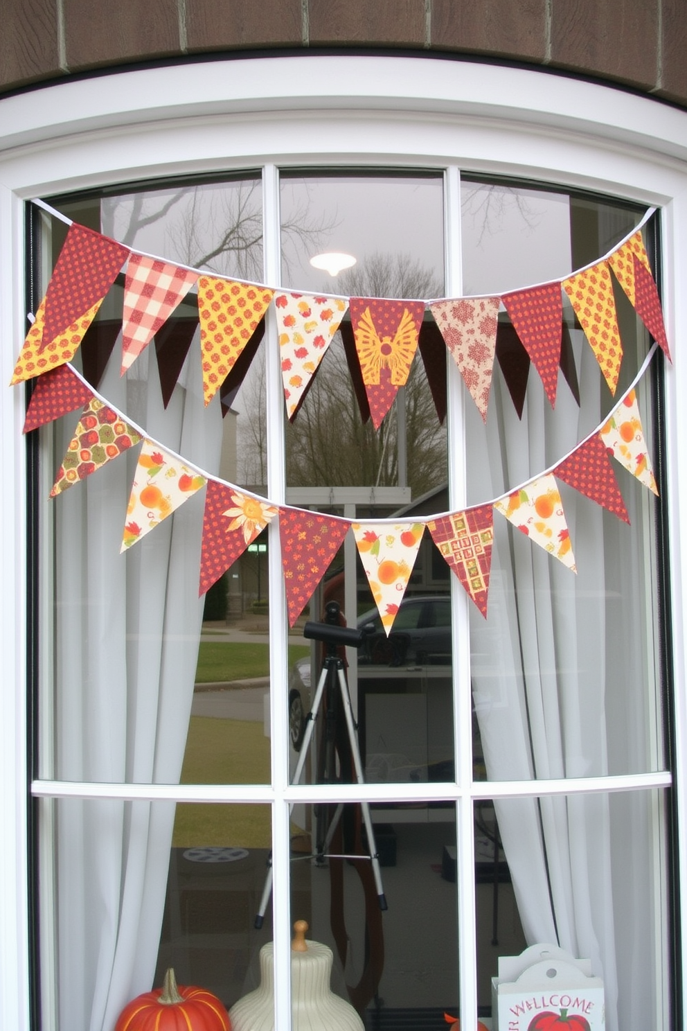 A cheerful Thanksgiving window display features colorful fabric bunting strung across the top of the window. The bunting is adorned with autumn-themed patterns and vibrant colors, creating a festive atmosphere that welcomes the holiday spirit.