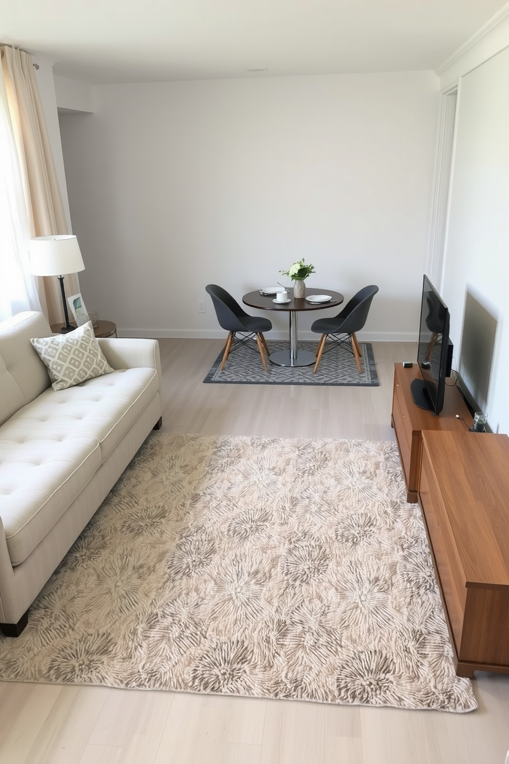 Cozy living area with a plush area rug that delineates the seating space from the dining area. The rug features a geometric pattern in soft neutral tones, complementing the light color palette of the apartment. In the corner, a compact dining table is surrounded by stylish chairs, creating an inviting atmosphere for meals. A smaller rug beneath the table adds warmth and further defines the dining zone.