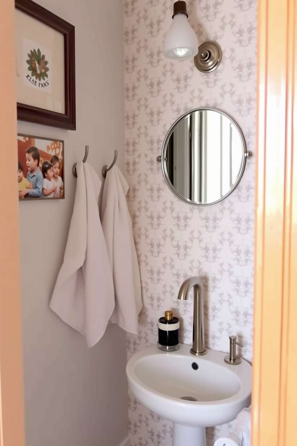 A charming tiny powder room features wall-mounted hooks for towels, elegantly positioned beside a compact sink. The walls are adorned with a playful wallpaper pattern, and a small round mirror adds depth to the space.