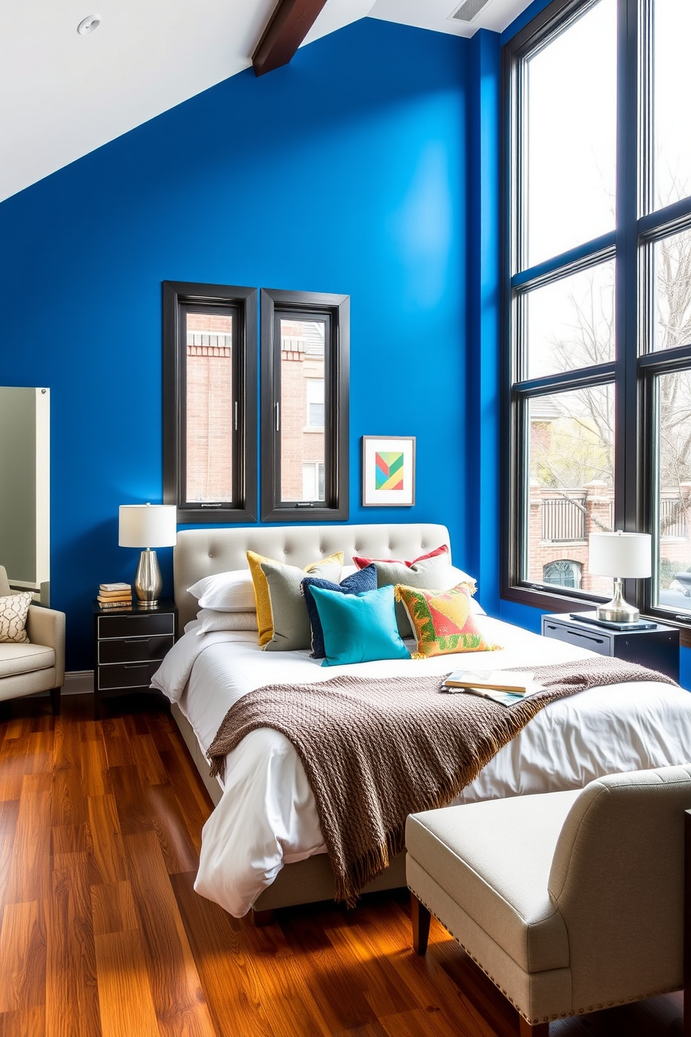 A bold accent wall painted in vibrant blue creates a stunning focal point in the townhouse bedroom. The room features a plush king-sized bed adorned with colorful throw pillows and a textured blanket, complemented by stylish bedside tables with modern lamps. Large windows allow natural light to flood the space, highlighting the rich hardwood flooring. A cozy reading nook with a comfortable chair and a small bookshelf adds a touch of warmth and invites relaxation.