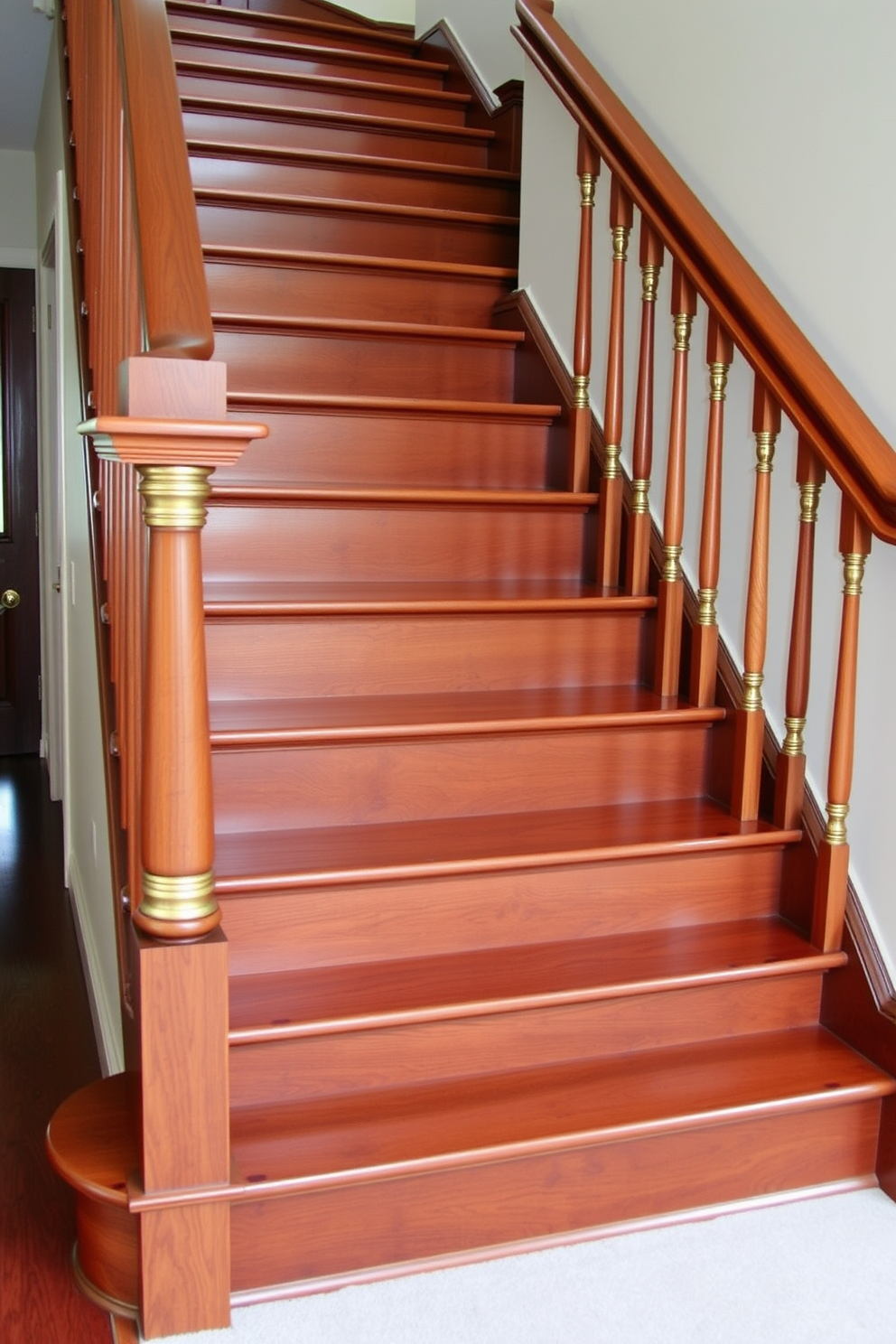 A traditional staircase design featuring richly stained oak wood treads. The balustrades are crafted from polished brass, complementing the warm tones of the wood.