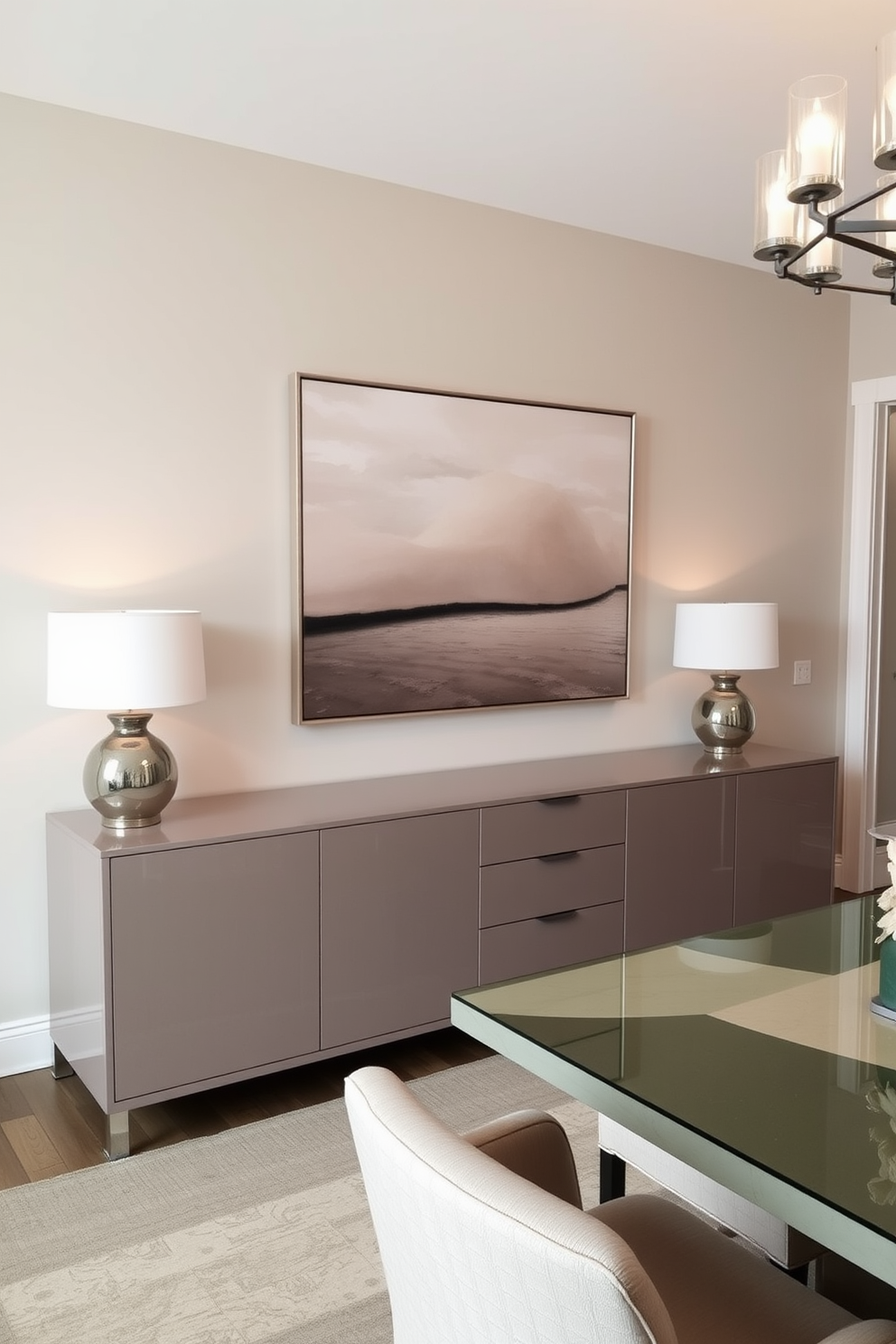 A sleek buffet with clean lines and a glossy finish is positioned against the wall, providing ample storage for dining essentials. Above the buffet, a large artwork in neutral tones adds a touch of elegance and style to the transitional dining room. The dining table features a mix of modern and traditional elements, with upholstered chairs that complement the overall color scheme. Soft lighting from a contemporary chandelier casts a warm glow, enhancing the inviting atmosphere of the space.