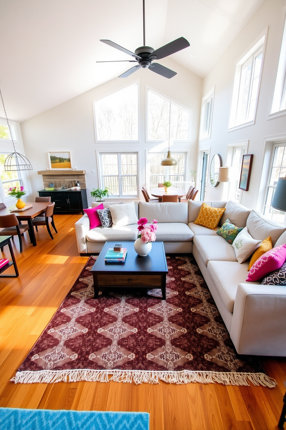 An open floor plan that emphasizes spaciousness and flow. The living room features a blend of modern and traditional elements with a large sectional sofa, a rustic coffee table, and a statement chandelier hanging above. Natural light floods the space through expansive windows, highlighting the warm wood tones of the flooring. Accents of soft textiles and bold artwork create a welcoming atmosphere that invites relaxation and conversation.