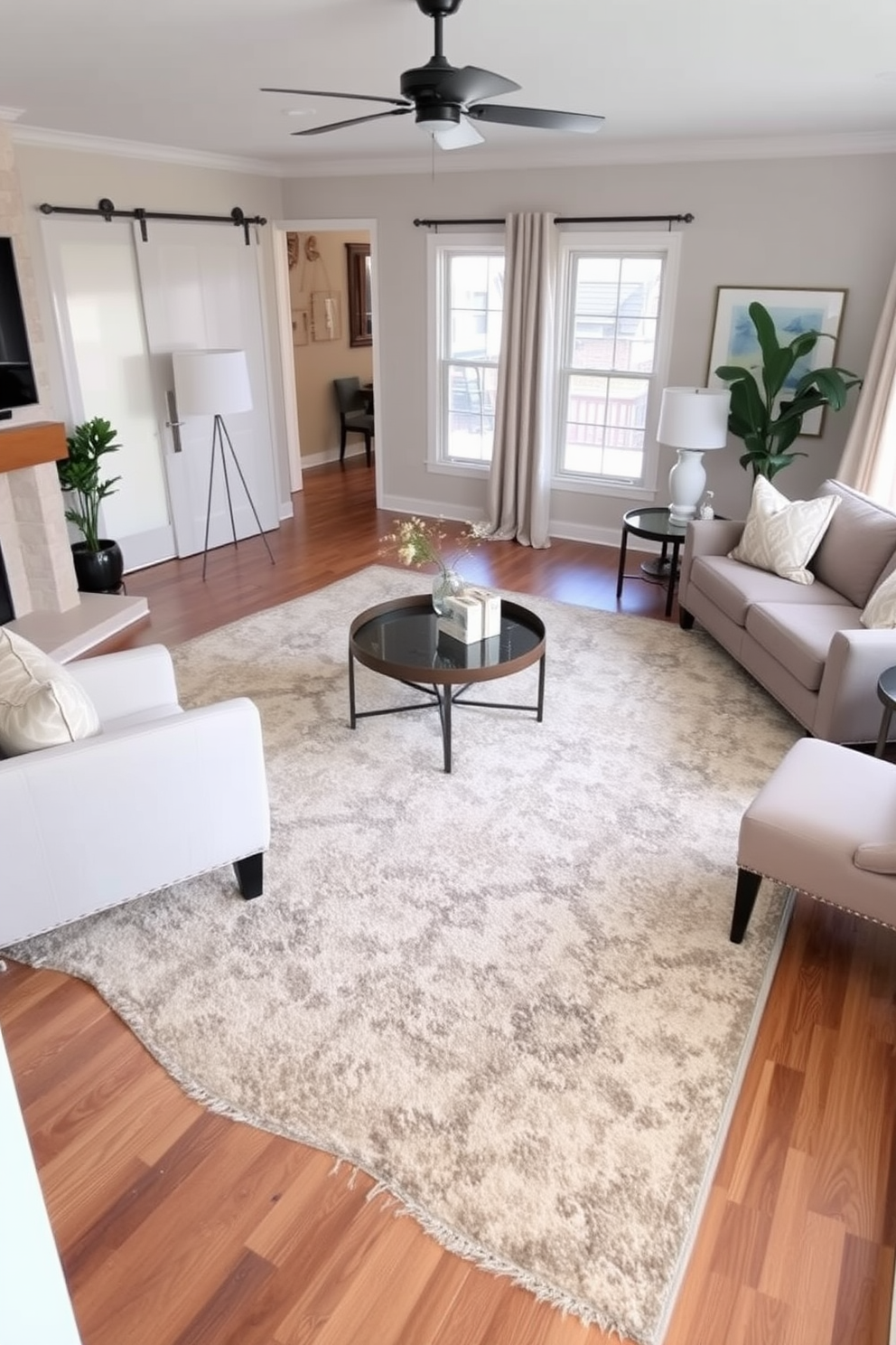 A cozy transitional living room featuring a large comfortable area rug that defines the seating area. The rug is layered over hardwood floors, complementing a mix of modern and traditional furniture pieces in neutral tones.